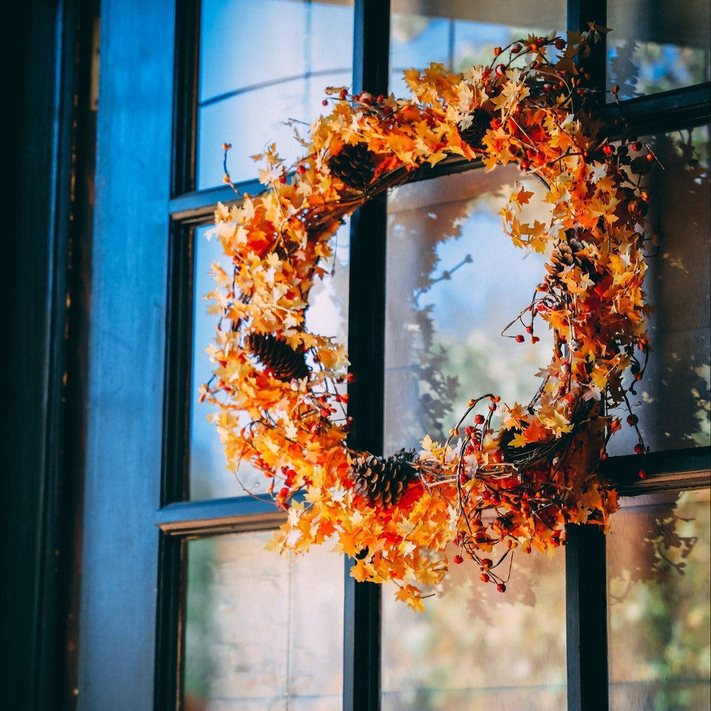 Fall leaf wreath hanging on a glass window with a magnetic hanger, no nails or tape