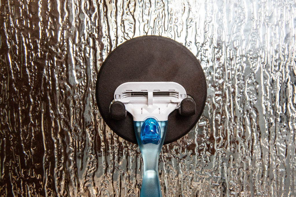 Blue and white razor on a magnetic razor holder, a no drill alternative to suction cups on glass
